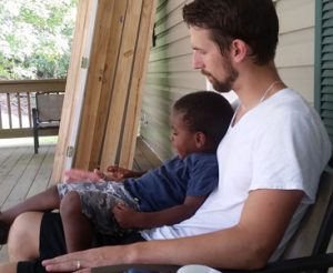 dad sits with child on porch | coyotehill.org