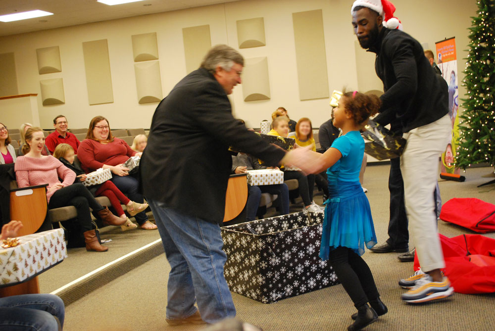 Young girl excited to give Larry McDaniel a Christmas gift | coyotehill.org